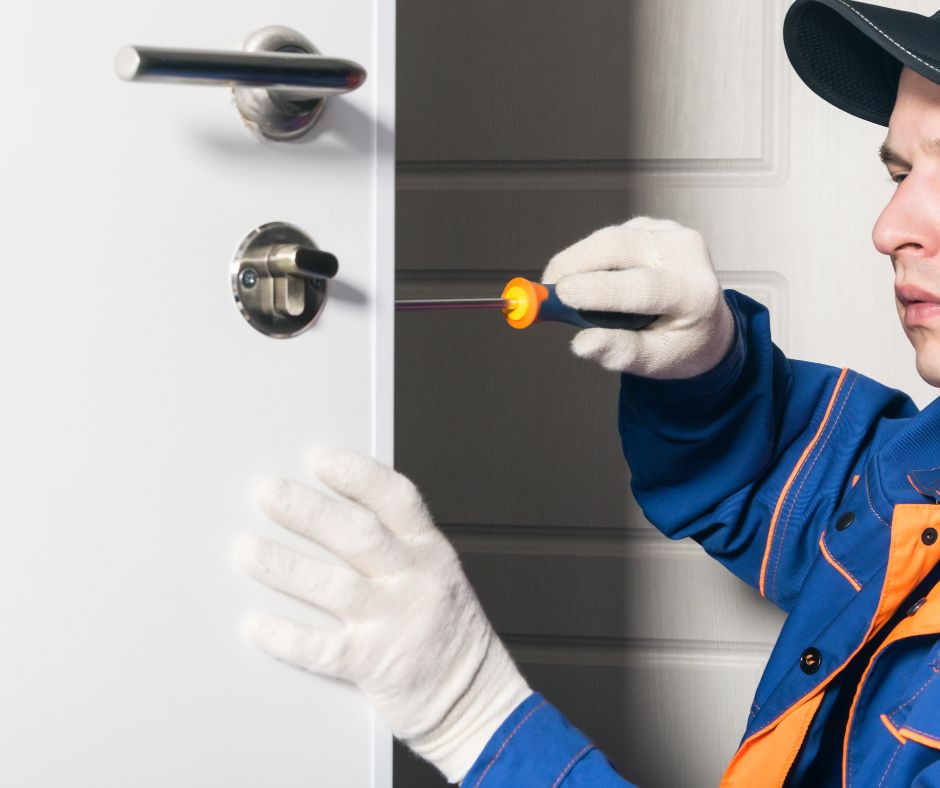 Uniformed locksmith installing high security lockset at office building entrance