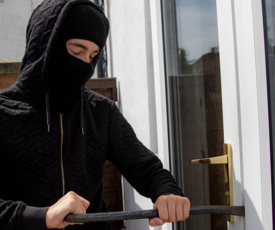 A burglar trying hard to break in a secured home by a Locksmith in Crawley