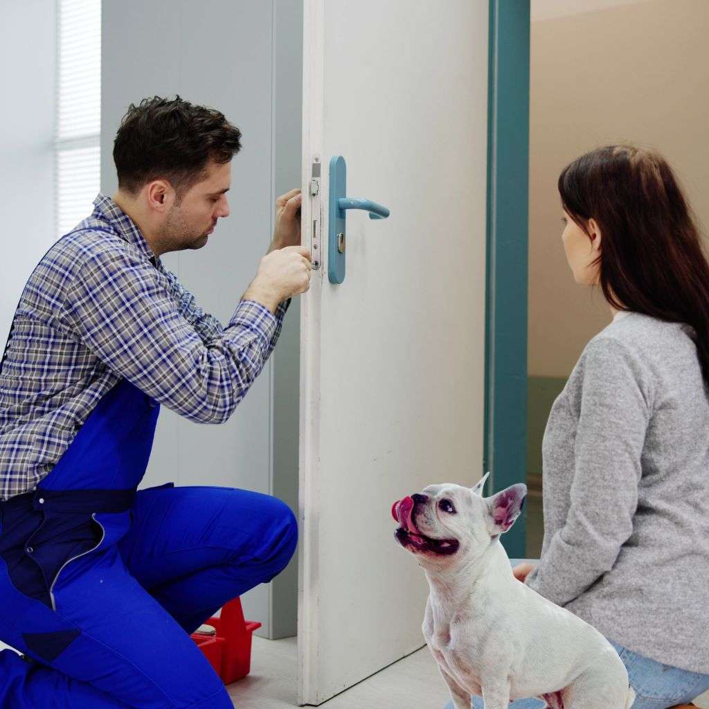 A locksmith in Crawley installing a pet-friendly home security system to protect a dog.